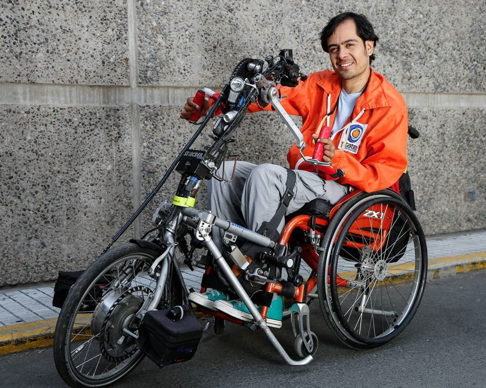 A customer with a manual Stricker handbike in front of a wall.